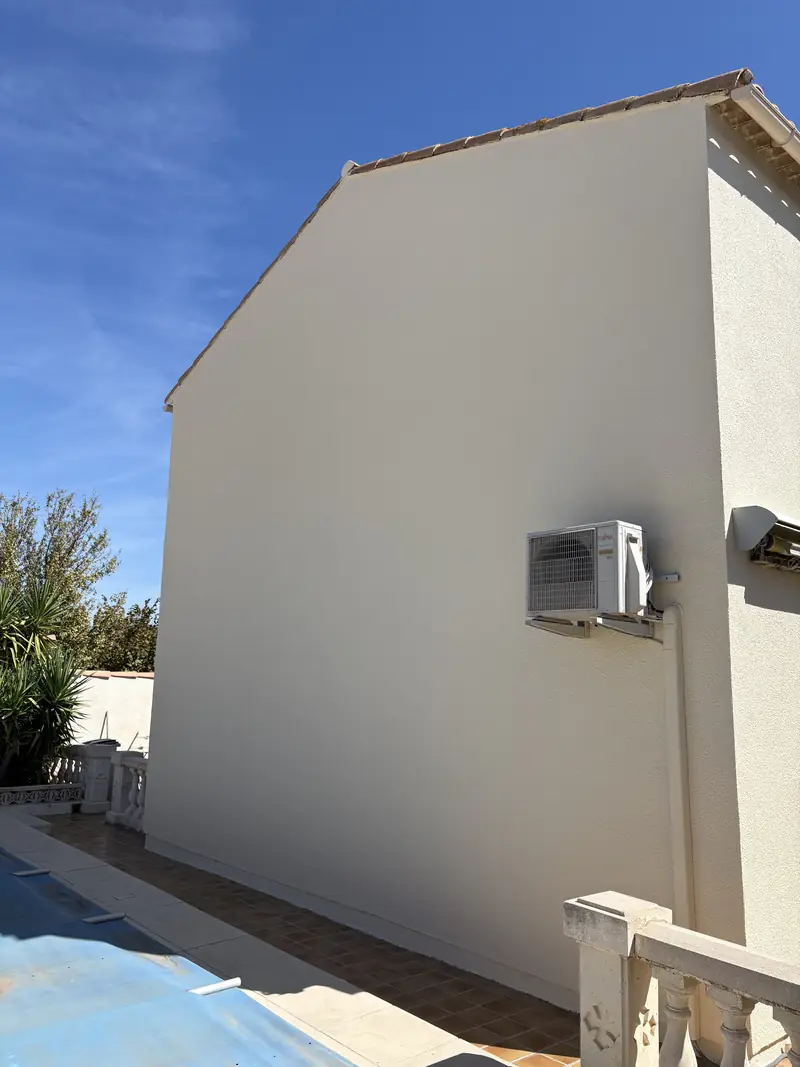 Grand mur pignon repeint à Béziers — façade crème uniforme avec pompe à chaleur et piscine