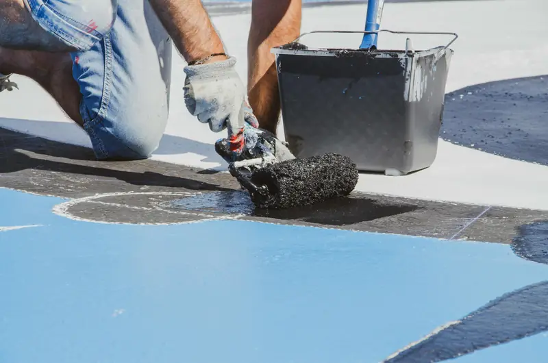 Application de peinture d'étanchéité au rouleau sur terrasse