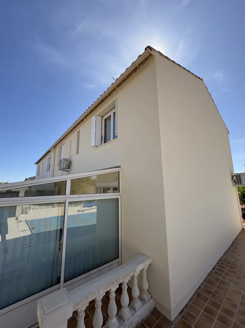 Pignon de maison ravalé à Béziers — enduit lisse beige près de la piscine et de la véranda